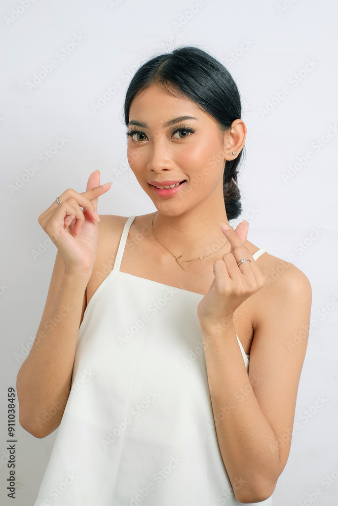 Beauty Asian Showing Korean Love Sign in White Tube Tops on White Background Beauty Asian Showing Korean Love Sign in White Tube Tops on White Background