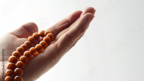 Close-Up of Hand Holding Jewish Prayer Beads Against White Background photo