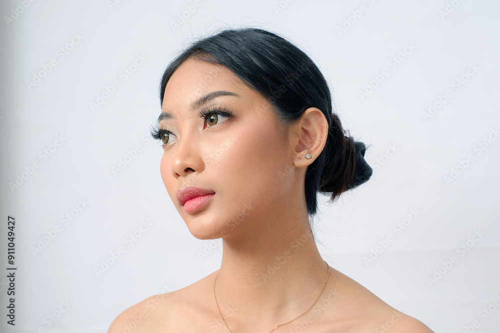 Closed Up Elegant Southeast Asian Woman with Glowing Brown Skin and Bun Hairstyle on White Background Closed Up Elegant Southeast Asian Woman with Glowing Brown Skin and Bun Hairstyle on White Background