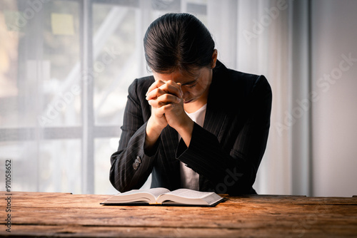 Hands folded in prayer on a Holy Bible in church concept for faith, spirituality and religion, woman praying on holy bible in the morning. woman hand with Bible praying.