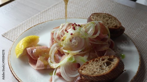 
Stroganina - frozen fish or meat cut into chips, one of the main dishes of northern cuisine, sauce pouring process photo