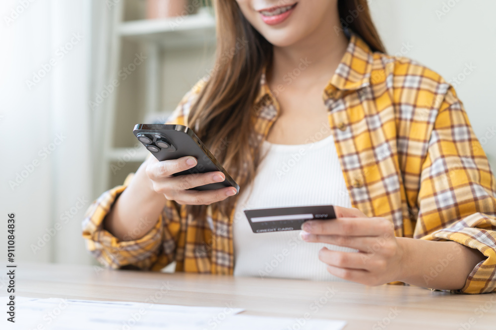 Bill pay, shopping order online internet asian young woman hand holding credit card and mobile smart phone on desk at home, female using banking service to secure payment with purchase on store. Bill pay, shopping order online internet asian young woman hand holding credit card and mobile smart phone on desk at home, female using banking service to secure payment with purchase on store.