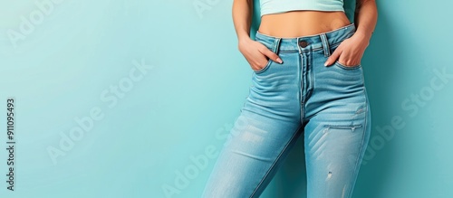 Weight loss and diet theme depicted by a closeup of a slim woman on a light blue background with a copy space image photo