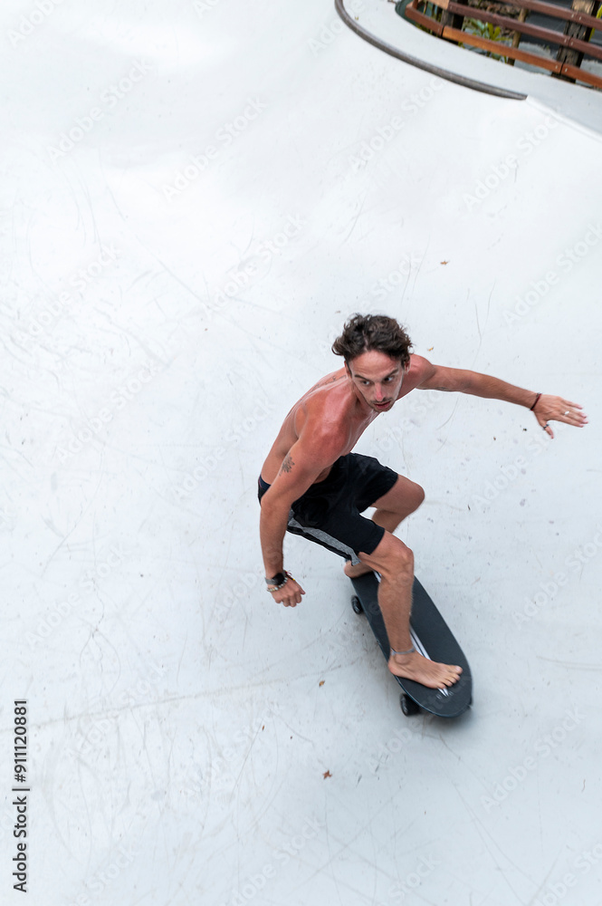 Shirtless skater in midturn on skatepark