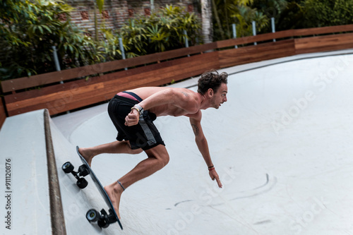 Barefoot skater leaning into sharp turn photo