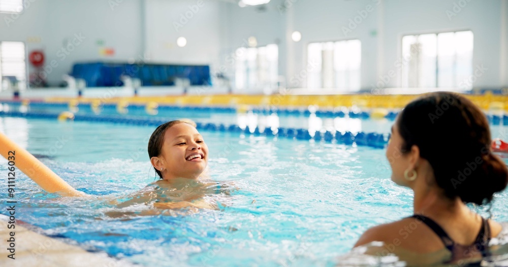 Fototapeta premium Instructor, water and girl in pool, swimming or woman with smile, proud or helping child in bathing suit. Teaching, happy or learning with teacher in school for training of kid, sports or competition