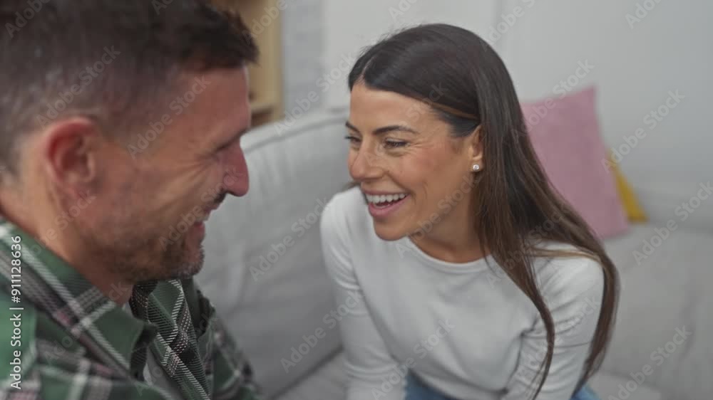 A happy hispanic couple enjoying a moment together on a sofa in a cozy living room setting A happy hispanic couple enjoying a moment together on a sofa in a cozy living room setting