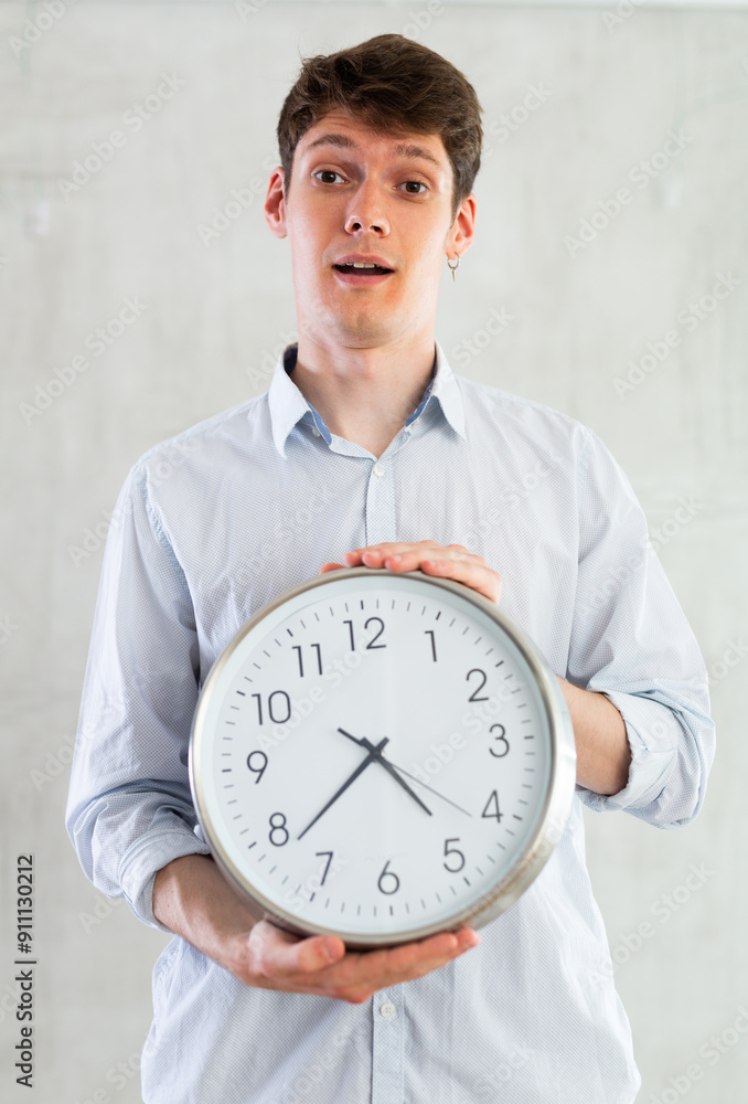 Man with a round big clock in his hands expresses various emotions