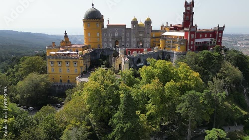 Ascending drone footage of Pena Palace on a sunny day in Sao Pedro de Penaferrim, Sintra, Portugal photo