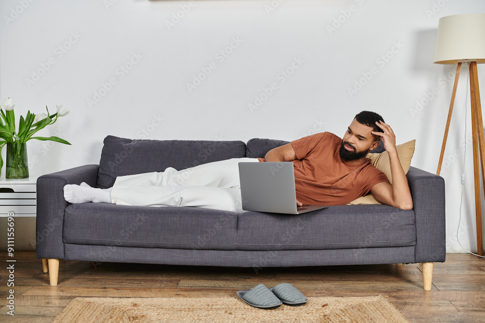 A man enjoys his leisure time while browsing on a laptop at home. A man enjoys his leisure time while browsing on a laptop at home.