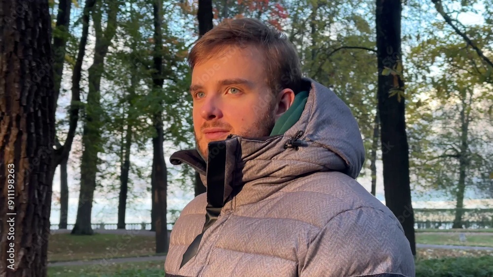 handsome young man walking in the park in autumn. Enjoying the weather, smiling, breathing fresh air handsome young man walking in the park in autumn. Enjoying the weather, smiling, breathing fresh air