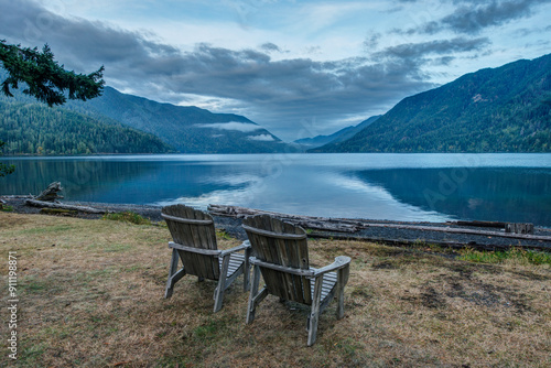 Two Adirondack style wooden lounge chairs by Crescent Lake at Olympic  National Park. photo