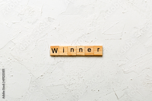 WINNER word written on wood block. WINNER text on cement table for your desing, concept photo