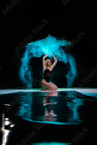 Obraz na płótnie Young slim woman posing with blue particles sprayed in the air w salonie