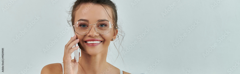 Bright smile enhances the playful vibe while chatting softly on the phone. Bright smile enhances the playful vibe while chatting softly on the phone.