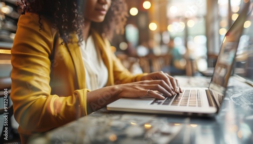 Young Woman Working on Laptop While Sitting at a Stylish Café During Daytime