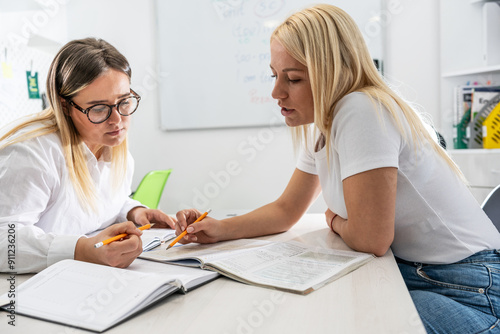 Two language learning students are focused on taking a test in their language class, showcasing their dedication to mastering a foreign tongue. 