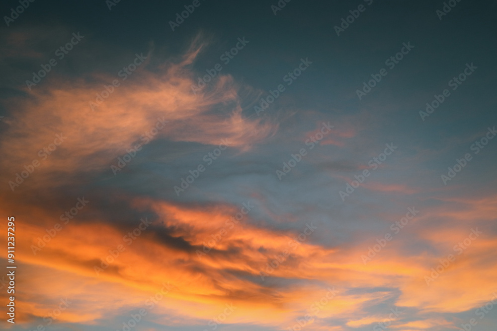 Fototapeta premium Orange cloud formations abstract nature background. Sky at sunset, orange cirrus clouds. Dramatic red and orange clouds.