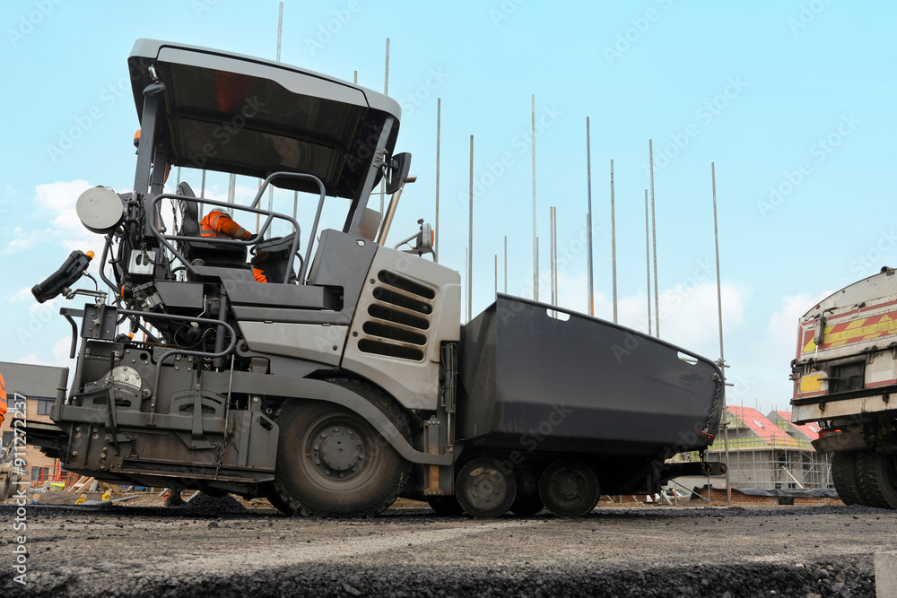 Construction Workers Operate Heavy Machinery on a Road Project at Daytime in an Urban Environment Construction Workers Operate Heavy Machinery on a Road Project at Daytime in an Urban Environment