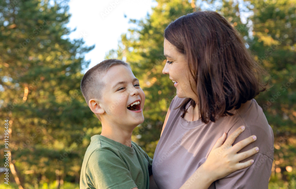 Happy mother and son laughing while standing in the park. Happy mother and son laughing while standing in the park.