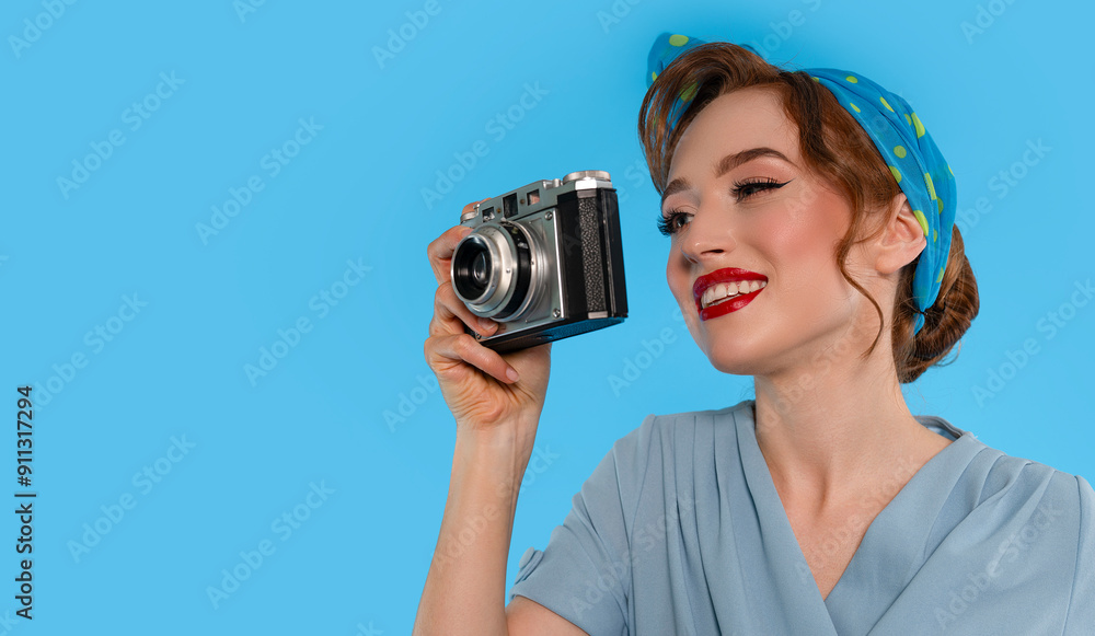 Young Woman in Blue Outfit Smiling While Holding Vintage Camera Against Bright Blue Background Young Woman in Blue Outfit Smiling While Holding Vintage Camera Against Bright Blue Background