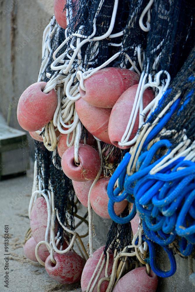 sieć rybacka z pływakami na brzegu, suszące sie na brzegu sieci rybackie z pływakami, fishing net on the shore, fishing net drying, Fishing net in the harbor, nets and floats are dried on the shore.