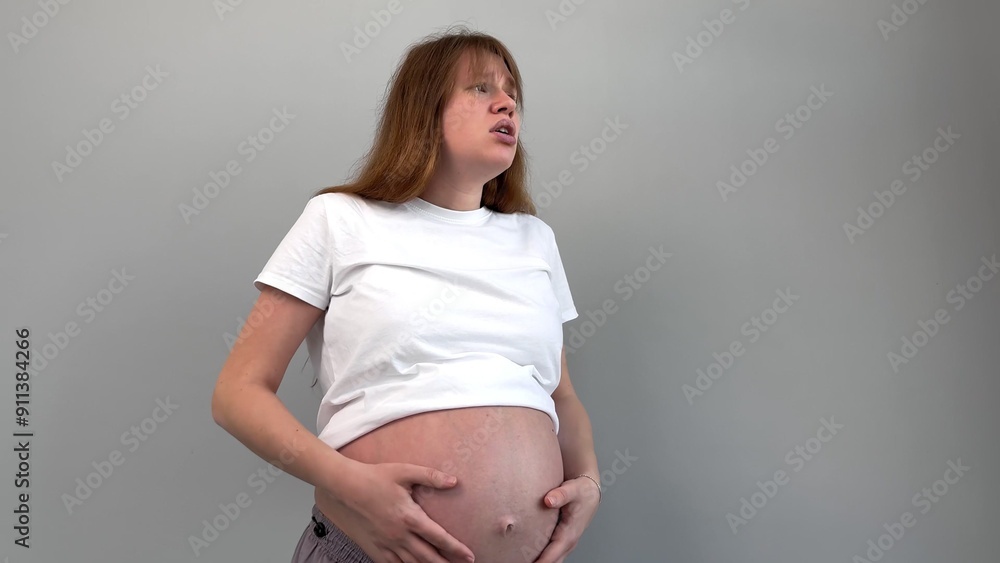 Sad frustrated pregnant woman feeling bad and stroking her big belly Sad frustrated pregnant woman feeling bad and stroking her big belly