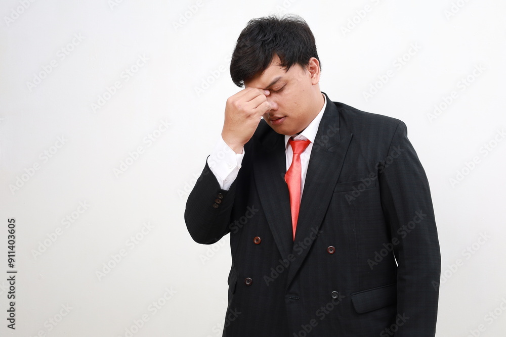 Young sick ill tired sad asian businessman keep eyes closed rub put hand on nose isolated on white background Young sick ill tired sad asian businessman keep eyes closed rub put hand on nose isolated on white background