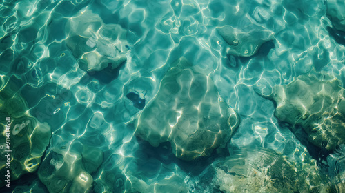 shimmering sun glares on shallow aqua sea water, top view, see rocks through