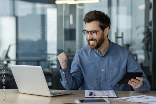 Canvas Print Happy financier working on laptop using calculator and phone in modern office