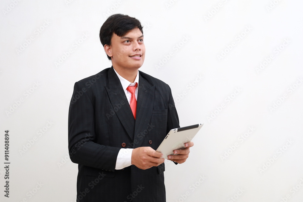 Young employee businessman standing use digital tablet computer look aside area isolated on white background studio Young employee businessman standing use digital tablet computer look aside area isolated on white background studio