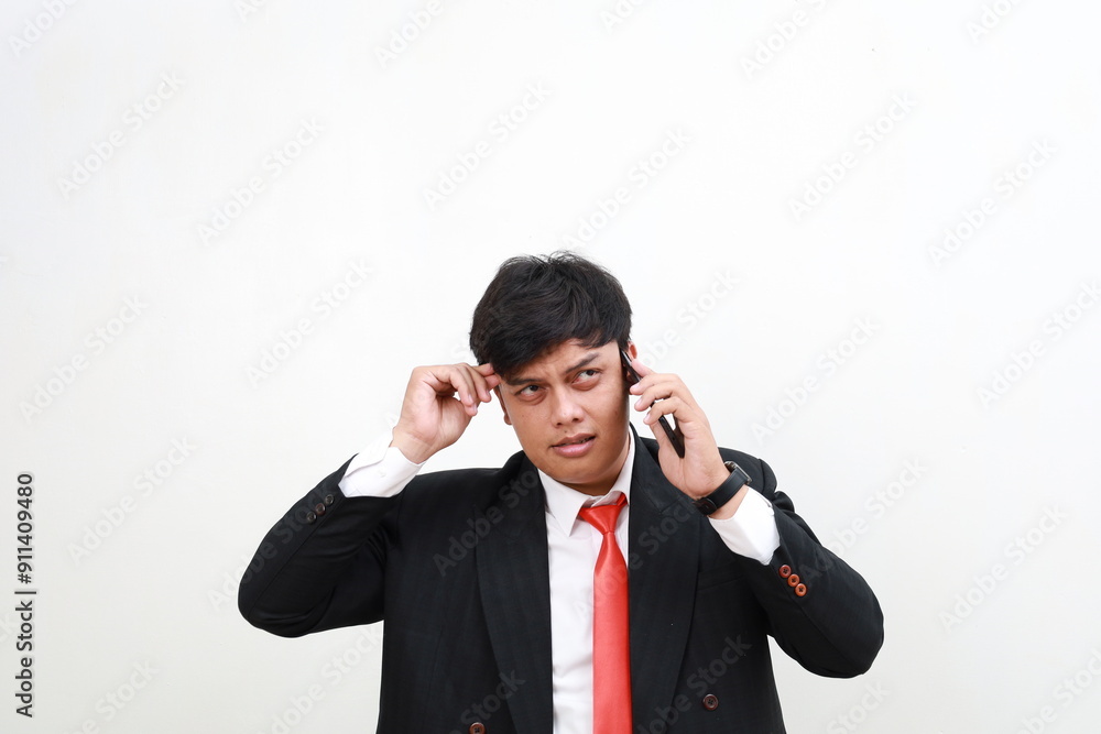 Stressed confused asian businessman having a phone call looking at empty space. Efficiency, planning and stress management concept
