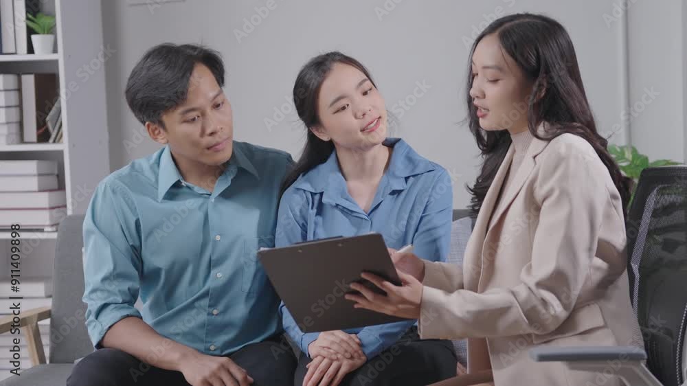 Business consultant discusses financial strategies with a young couple in an office. The couple listens attentively and asks questions Business consultant discusses financial strategies with a young couple in an office. The couple listens attentively and asks questions