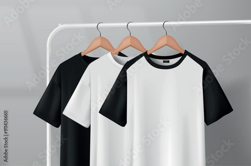 Black and white t-shirts hanging on a clothes rack in a studio on a wooden hanger.