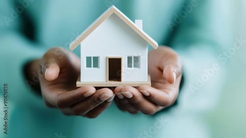 Hands holding a house model with protective umbrella, symbolizing insurance coverage, property insurance, coverage symbol