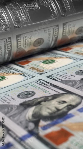 100 USA dollars banknotes are being printed by currency press machine. Close up background showing a process of american bills printing. Loop video of money printing process. Vertical, phone wallpaper