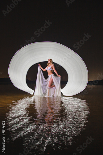 Young slim girl posing in water with abstract light effect