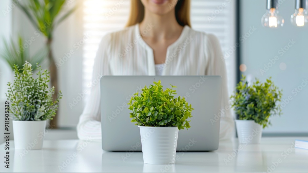 A photograph of an educator preparing lesson slides, wearing a white blouse and typing on a laptop A photograph of an educator preparing lesson slides, wearing a white blouse and typing on a laptop