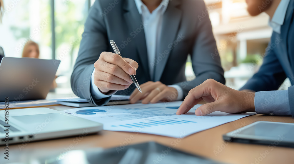 Business professionals discussing charts and data during a meeting, focusing on strategy and planning Business professionals discussing charts and data during a meeting, focusing on strategy and planning