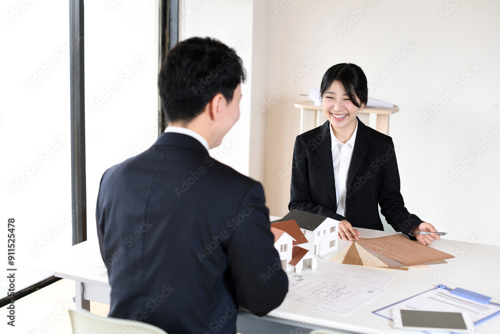 住宅模型を使い会議をする若い男女の会社員