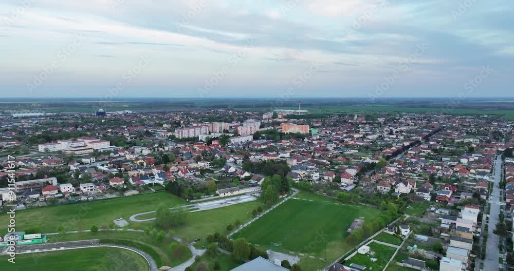 Aerial view of town during golden hour, with clouds over the horizon. Flying near town Aerial view of town during golden hour, with clouds over the horizon. Flying near town