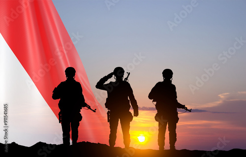 Silhouettes of a soldiers with Indonesia flag against sunset. National holidays, Independence Day concept photo