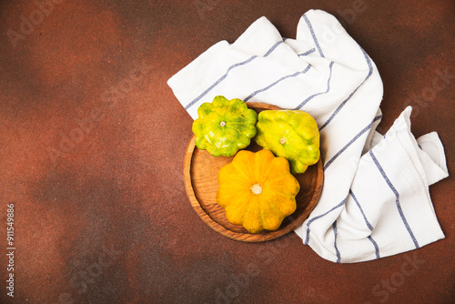 Pattypan zucchini on a textured kitchen table. squash. Fresh organic pattypan squashes on background. Vegan. Farmer's Market. Patisson. Space for text. Copy space. photo