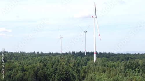 Drohne fliegt über Wald mit Windkraftanlagen bei Windstille, Alternative Energie, Energiewende, Luftaufnahme photo