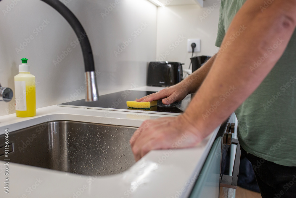 housekeeper Man Washing The Dishes on minimalistic kitchen. housekeeper Man Washing The Dishes on minimalistic kitchen.