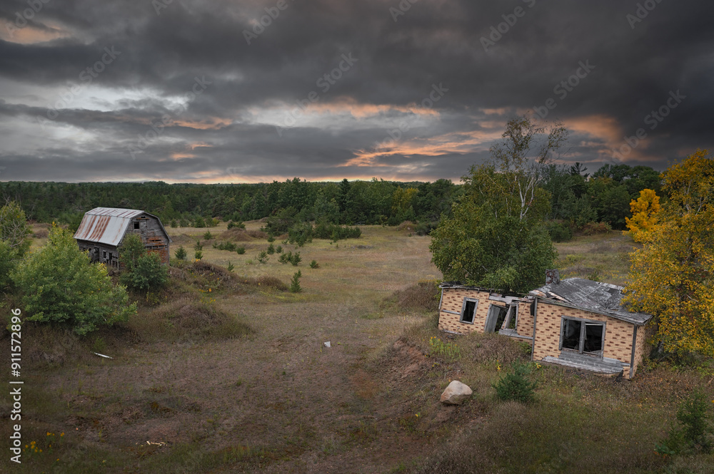 Dilapidated House and Barn Under Grim Skies