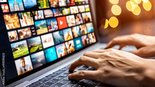Close-up of hands typing on a laptop keyboard against a background of an illustration or a glowing video player window 