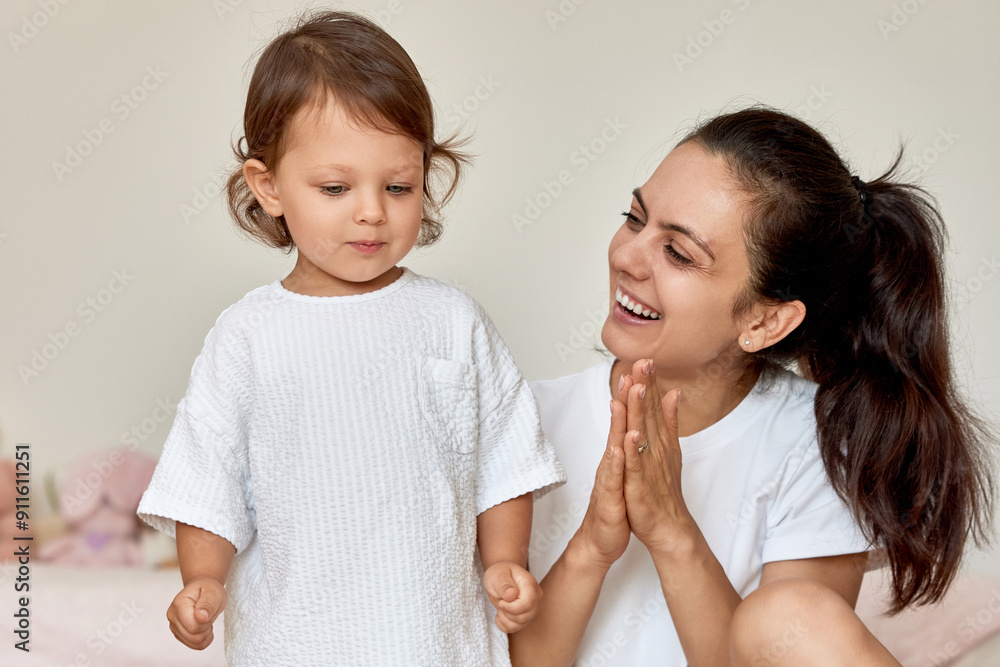 loving mother applauding to her cute baby girl in her room, support and motivation of the child loving mother applauding to her cute baby girl in her room, support and motivation of the child