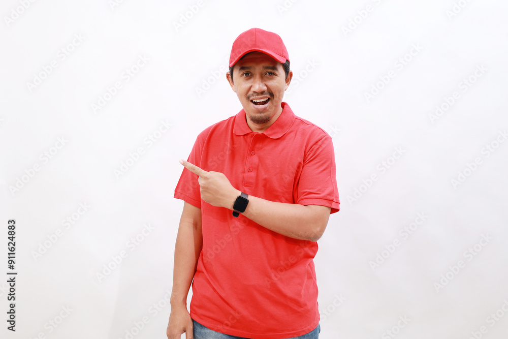 Professional fun delivery employee man wear red cap t-shirt uniform workwear work as dealer courier point index finger aside on area isolated on white background studio. Service concept Professional fun delivery employee man wear red cap t-shirt uniform workwear work as dealer courier point index finger aside on area isolated on white background studio. Service concept