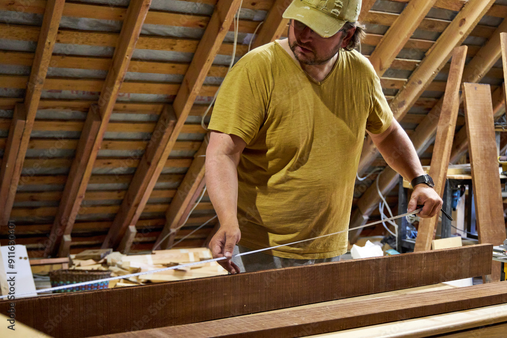 a man in a home carpentry shop selects boards for work a man in a home carpentry shop selects boards for work